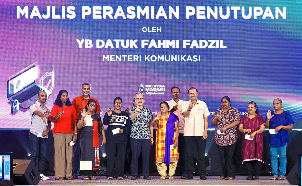Staying vigilant: Fahmi (centre) with participants of an awareness seminar on online scams held yesterday. The seminar was attended by 100 Indian youths from several public housing areas in Lembah Pantai. — FAIHAN GHANI/The Star 