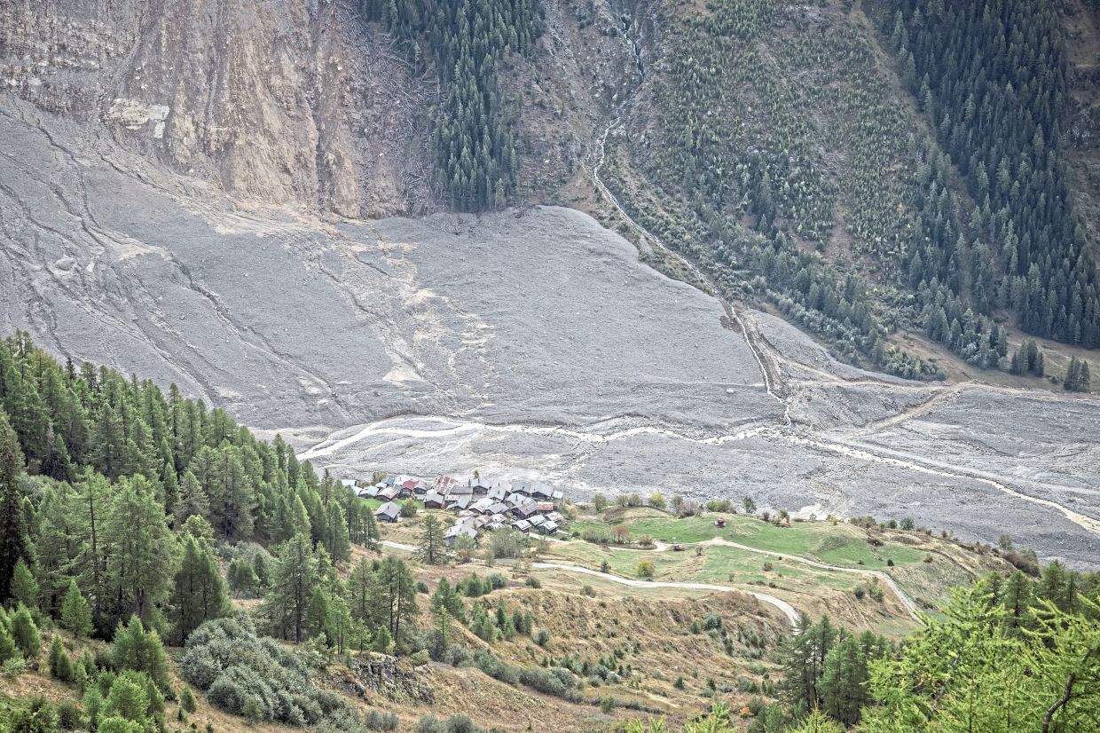 A few houses remain at the edge of the landslide in the village of Blatten, which was crushed by a glacier.