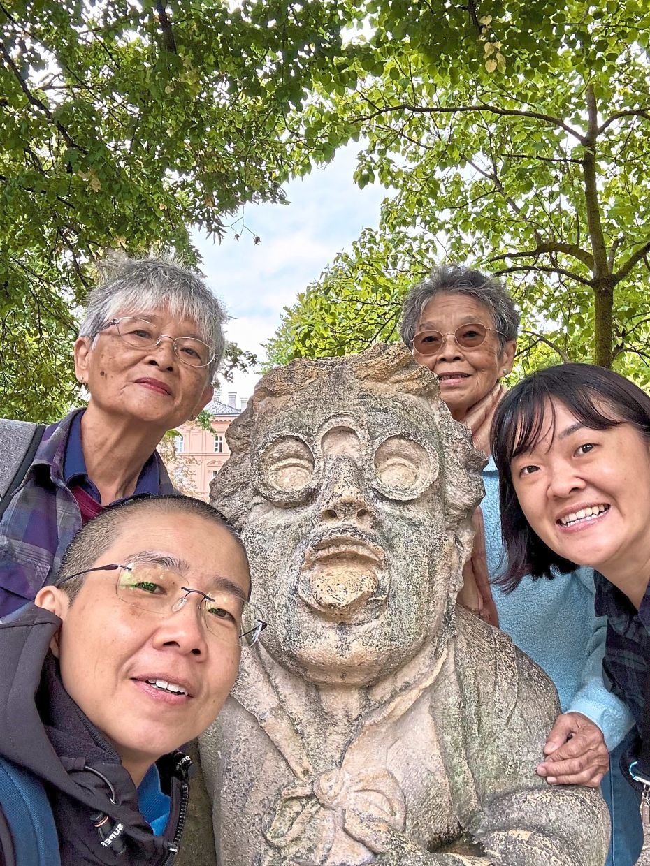 The writer (bottom right) and her companions take a quick wefie with Salzburg’s most famous dwarf at Mirabell Gardens.