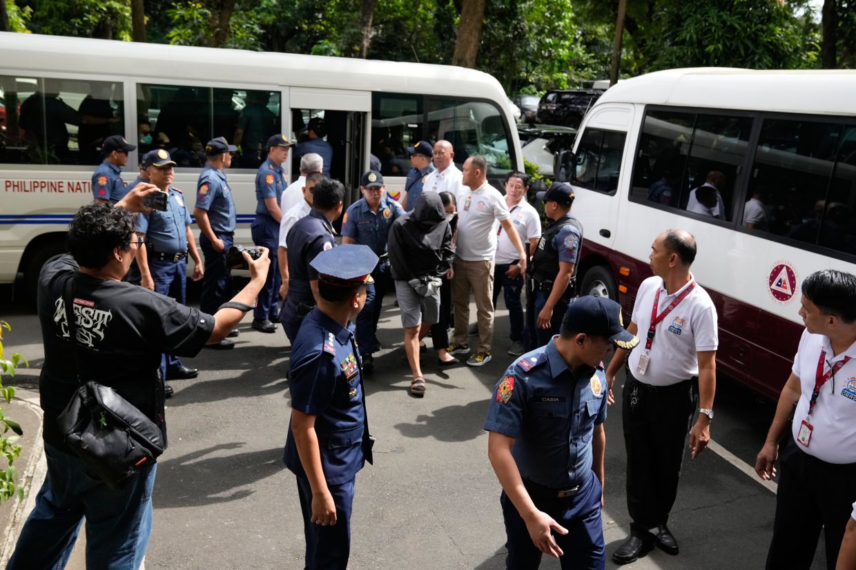 Police escort the initial batch of arrested suspects in a major corruption scandal involving flood control projects as they arrive at the Sandiganbayan, a special anti-corruption court, in Quezon City, Philippines, on Monday, Nov. 24, 2025. -- Photo: AP Photo/Aaron Favila