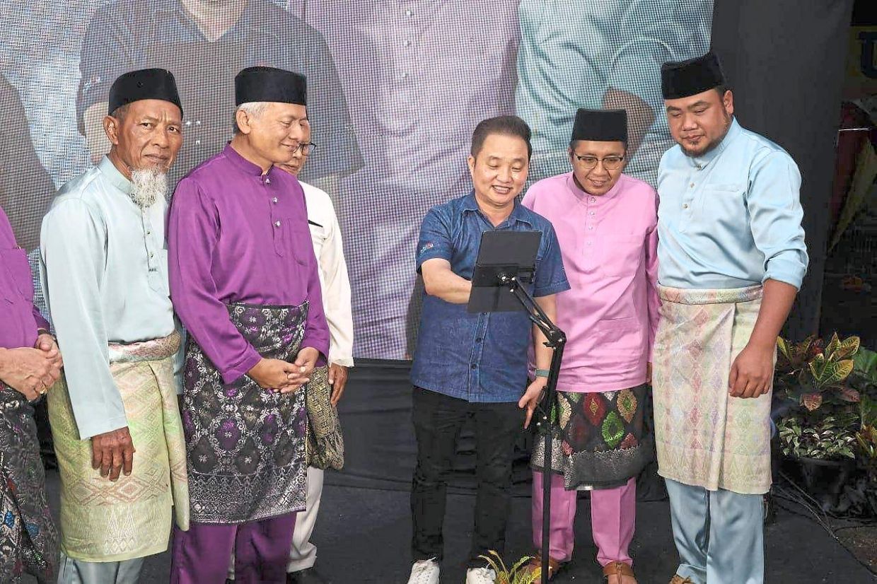 Ng (centre) launching the ‘Sedulur Sekampung’ website during a Hari Raya Aidilfitri event.