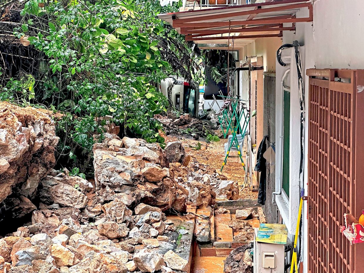 Badly affected:A car is damaged after the collapse of a retention wall along Jalan Sepadu 7, Taman United, Kuala Lumpur. — LOW LAY PHON/The Star