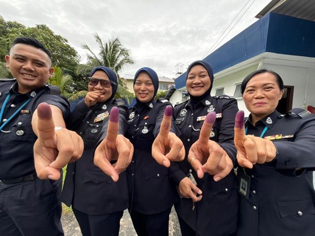 Sjn Nurhayati Ibrahim (middle) and her colleagues showing their inked fingers after casting their ballots at the IPK Sabah Officers’ Mess on Tuesday.