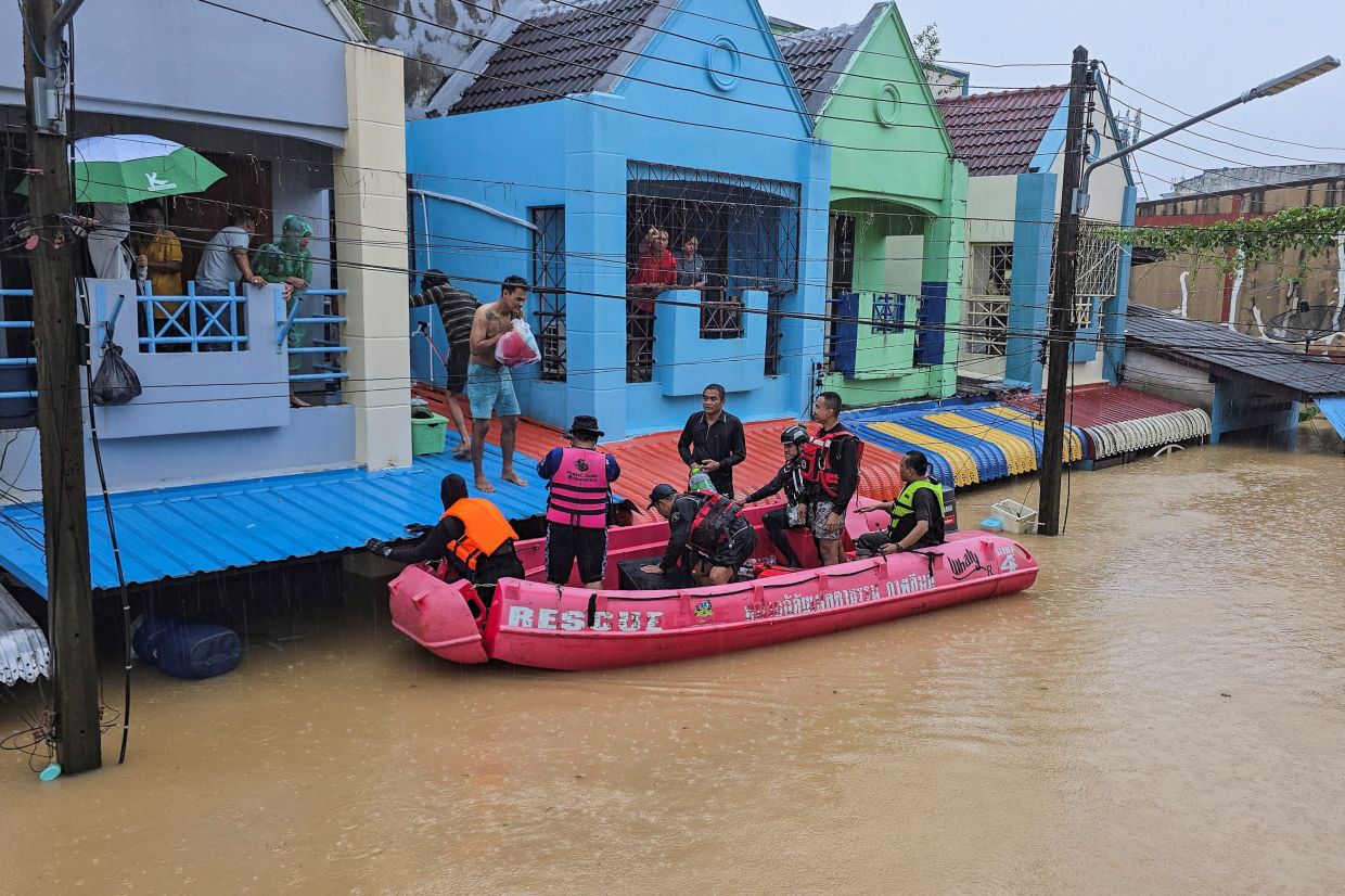 Thailand floods kill 13, leaving people stranded and roads submerged