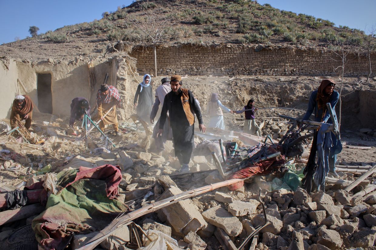Afghan men searching through rubble at the site of an overnight attack on a home that, according to an Afghan government spokesman, was carried out by Pakistan, in the Gurbaz district of Khost province, Afghanistan on Nov 25, 202- AP