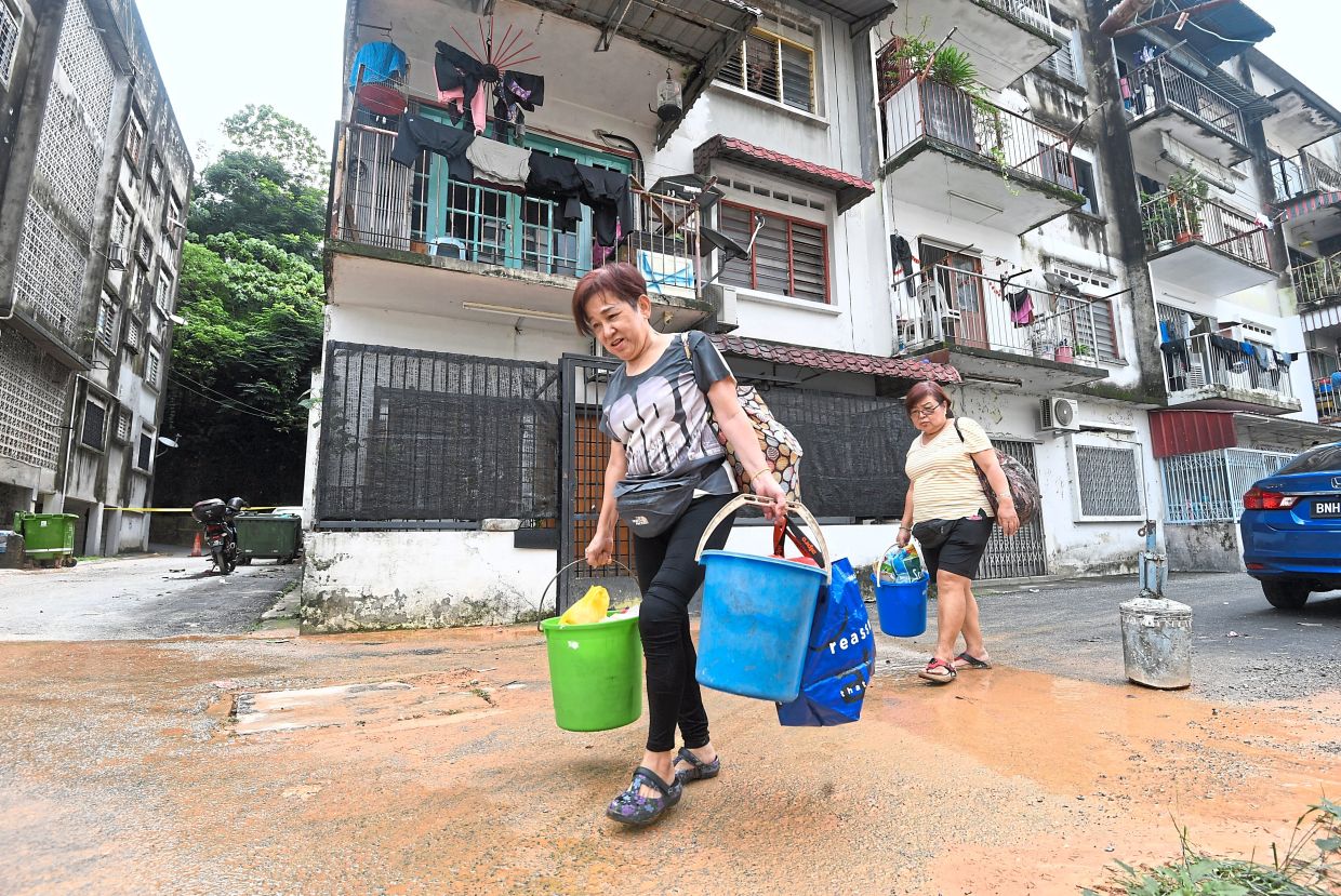 Several residents made a quick visit to their flats in Taman United yesterday to grab belongings. — Photos: AZHAR MAHFOF/The Star