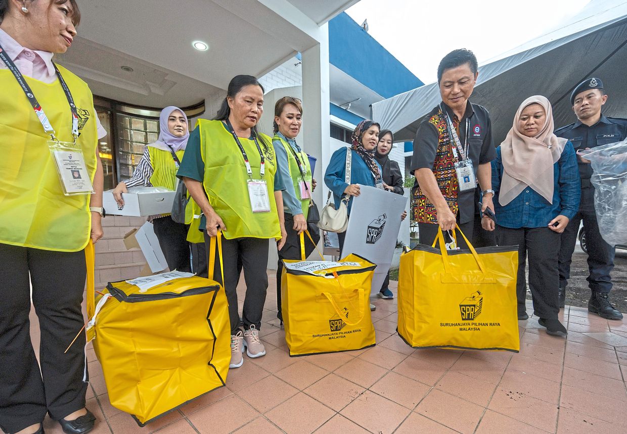 EC officers carrying ballot bags.