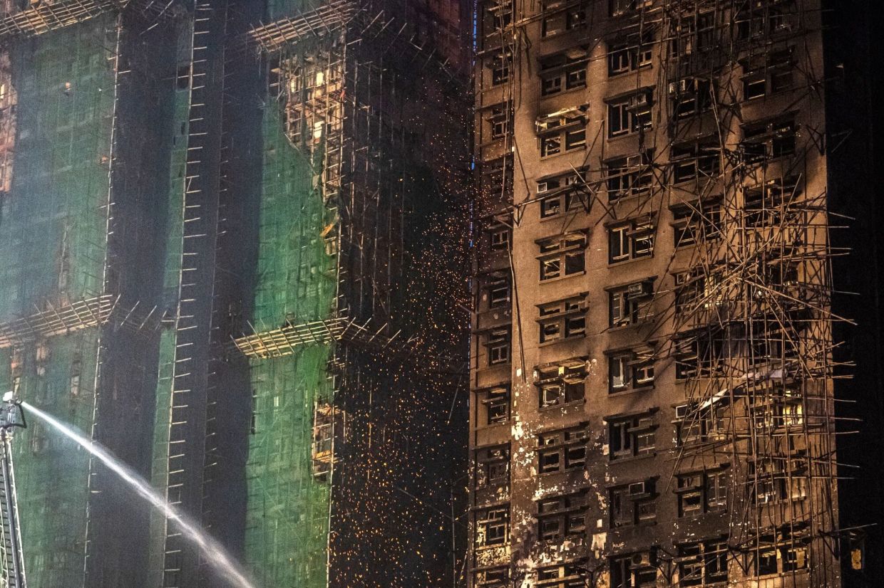 Sparks and burning debris scatter from the Wang Fuk Court residential estate on Nov 27, a day after the blaze. - Bloomberg