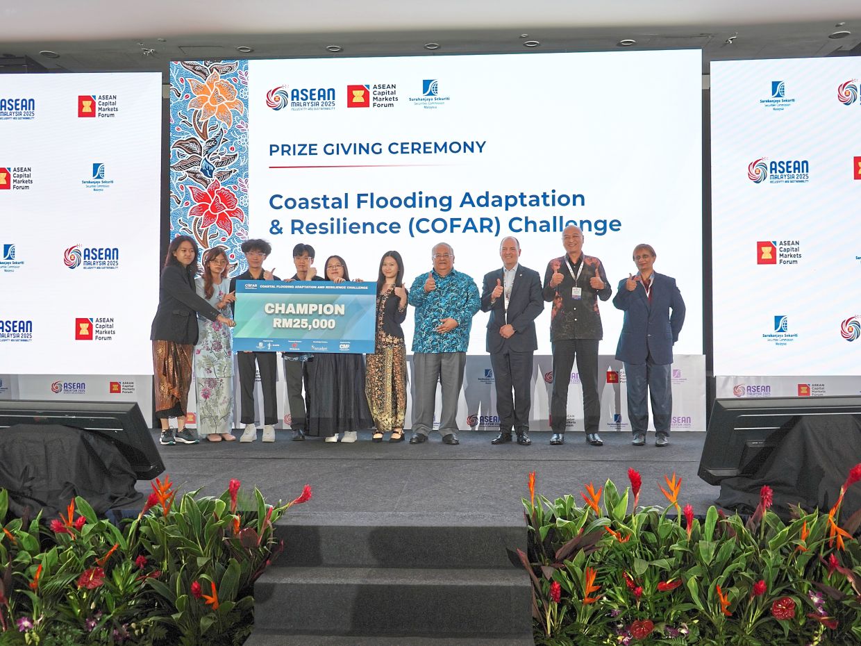 Champions of the COFAR challenge displaying their prize at the Asean Capital Markets Forum International Conference, which is held at the SC. 