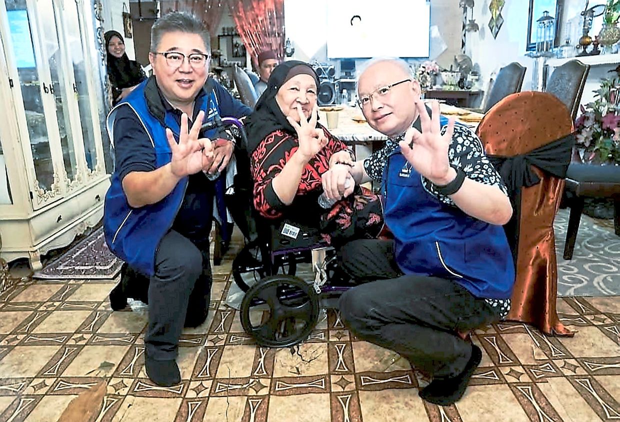 Reaching out: Chin (left) and Wee visiting a family on the sidelines of his campaign trail in Karamunting.