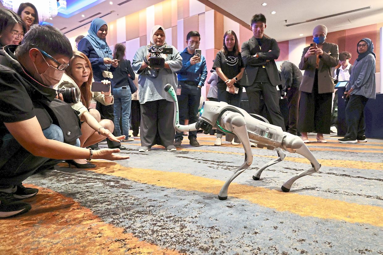 Conference participants interacting with the quadruped robot Unitree Go2 Air.