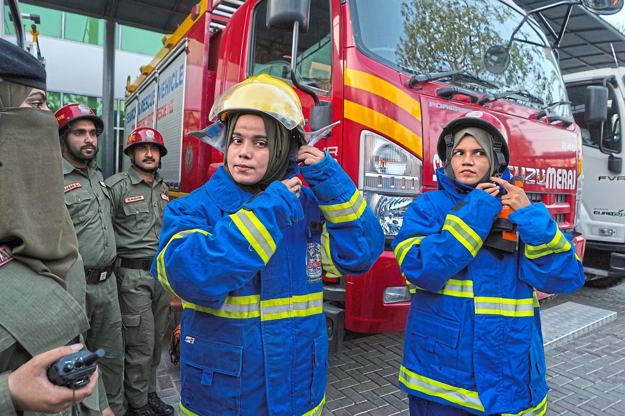 Prepared for anything: (Above, below) Syeda preparing with her team during a routine training session, at their office compound in Karachi. — AP