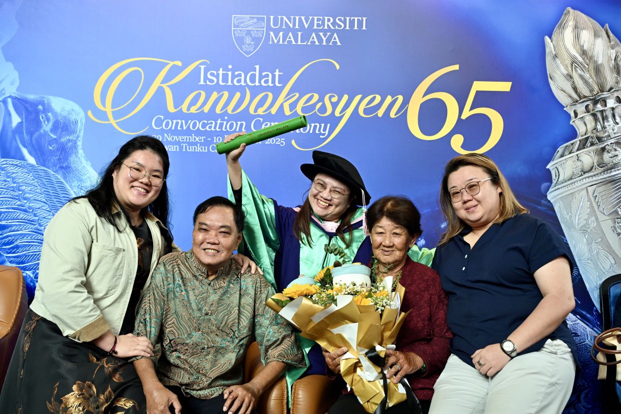 Chin with her family at the UM convocation ceremony after receiving her scroll.