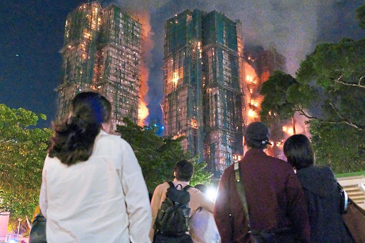 Raging fire: People looking on helplessly as thick smoke and flames rise during the fire. — AFP
