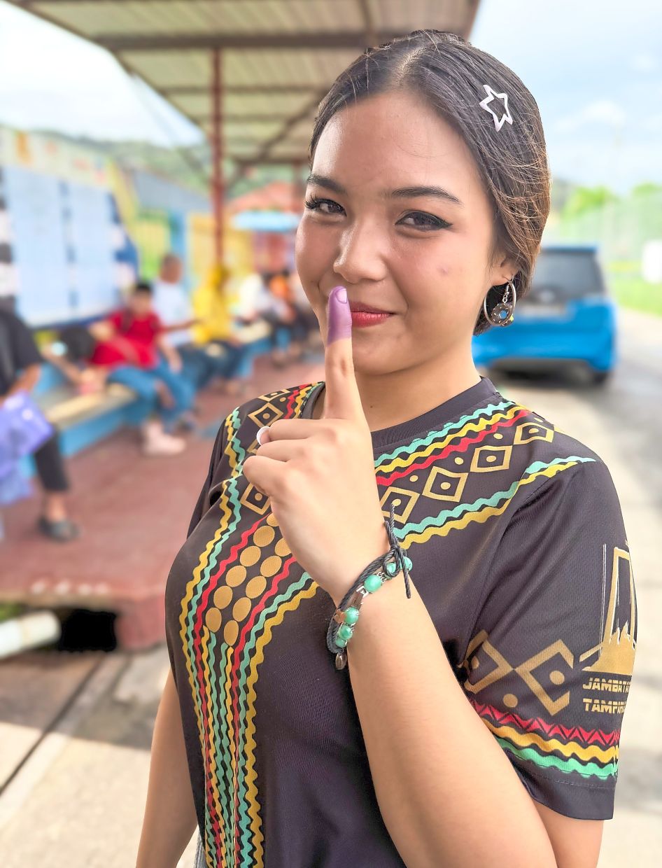 (MAIN PIX) Student and first-time voter Nur Alya Ramadhani, 19, was excited to fulfil her democratic responsibility.“It was nervous but at least we play our part for Sabah,” she said. — ZULAZHAR SHEBLEE / The Star