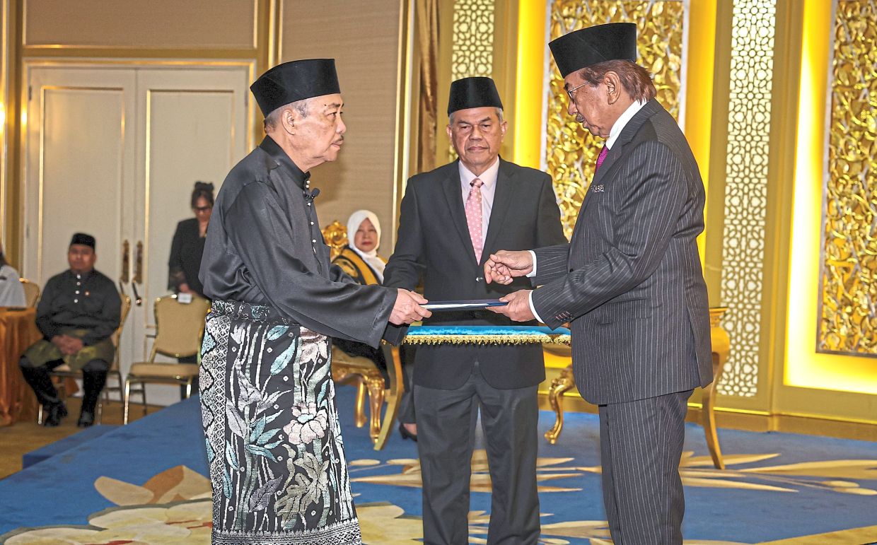 An honour: Hajiji taking the oath before Musa during the swearing-in ceremony at Istana Seri Kinabalu following the conclusion of the 17th Sabah state election. — Bernama