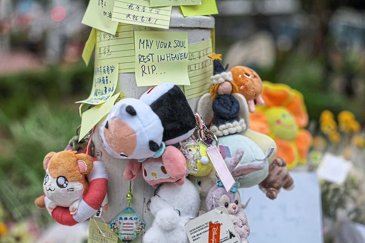 Toys and condolence notes left on a utility pole at a makeshift memorial for victims of the deadly fire in Hong Kong’s Central district. — AFP/AP