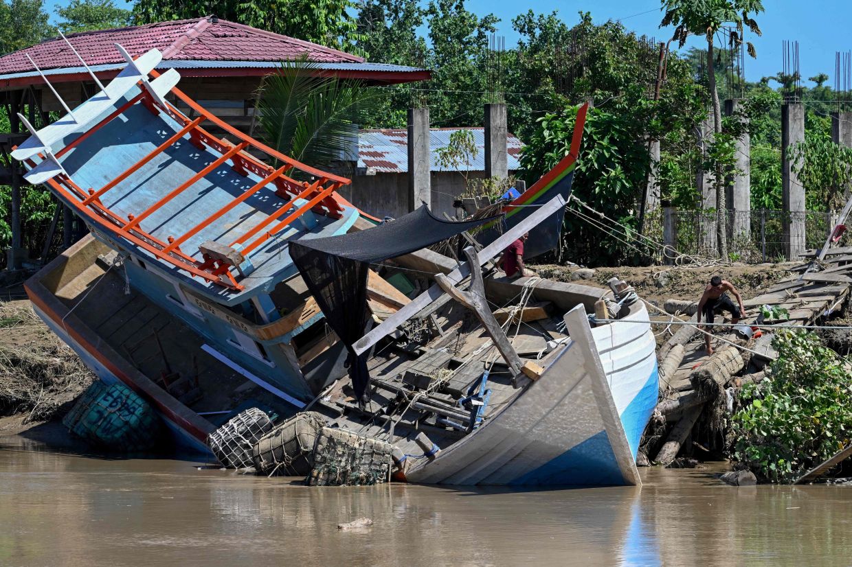 A fisherman's boat is seen washed up ashore in the aftermath of flash floods in Meureudu, Pidie Jaya district in Indonesia's Aceh province on Nov 30, 2025. - AFP
