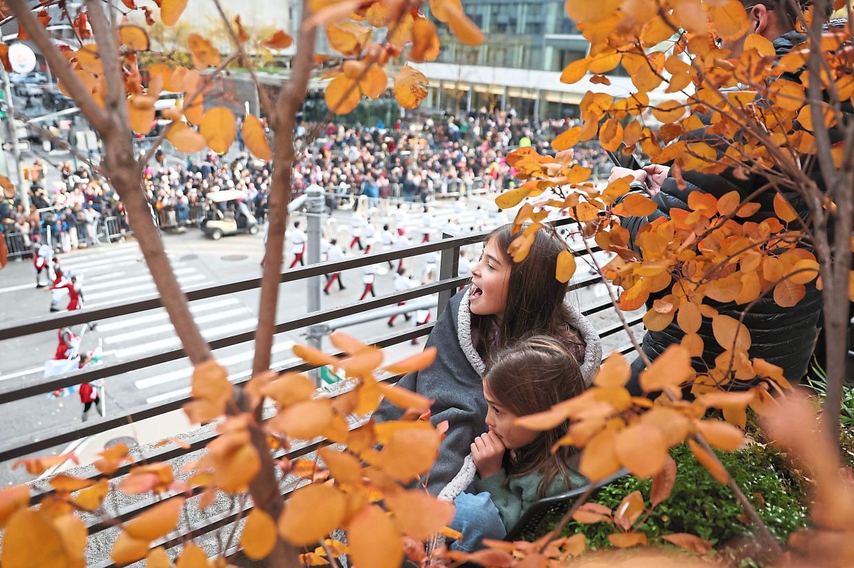 9. Children watching the Macy’s Thanksgiving Day Parade as it moves down sixth avenue. — AP