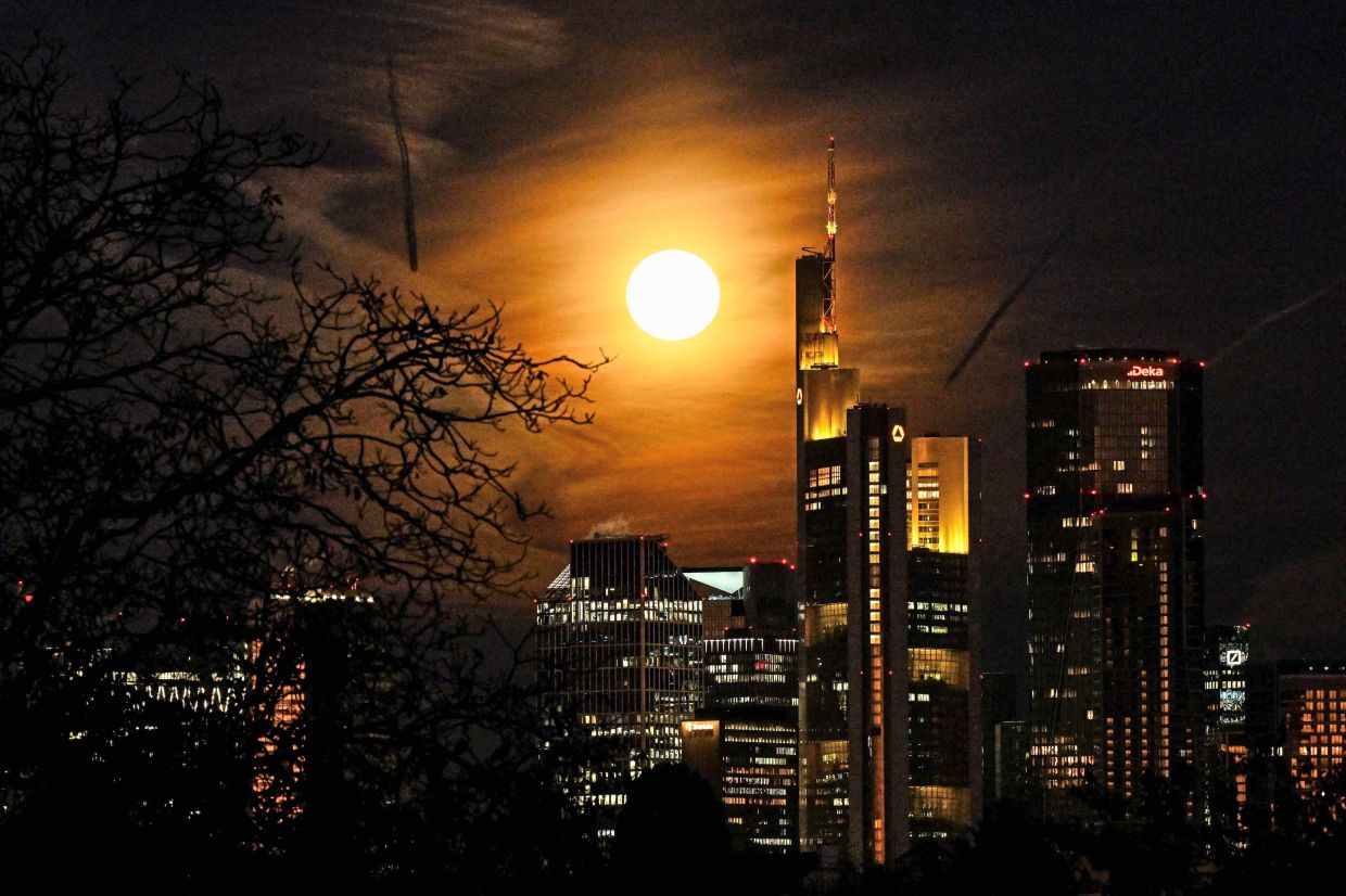 2. The Beaver Moon, is seen behind the headquarters of Commerzbank bank in the banking district of Frankfurt am Main, western Germany. — AFP