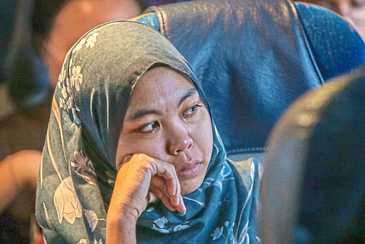 3. A woman tearing up amid floods in Bukit Kayu Hitam, Kedah. — Bernama