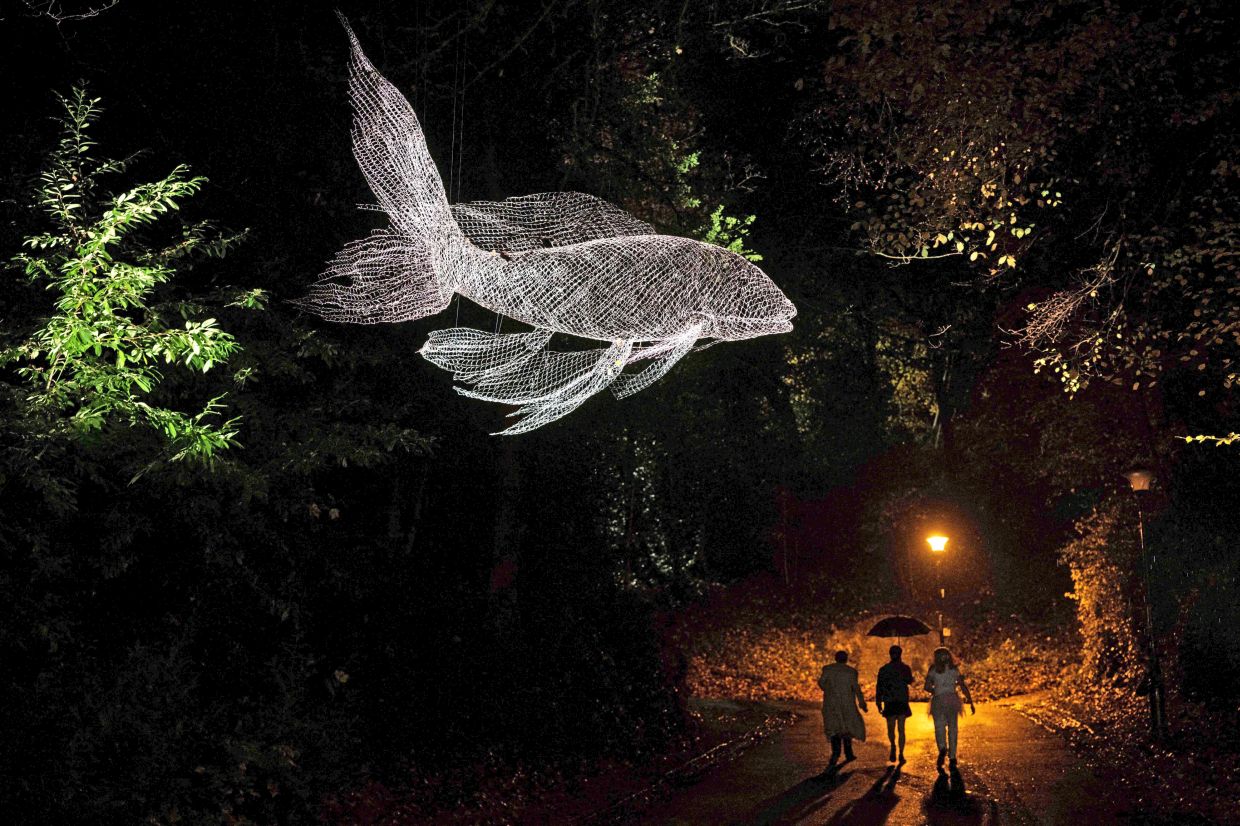 3. Visitors admiring the light art installation ‘The River’ by French artist Cedric Le Borgne during a photocall for ‘Lumiere’, a light art biennial festival in Durham, northeast England. — AFP