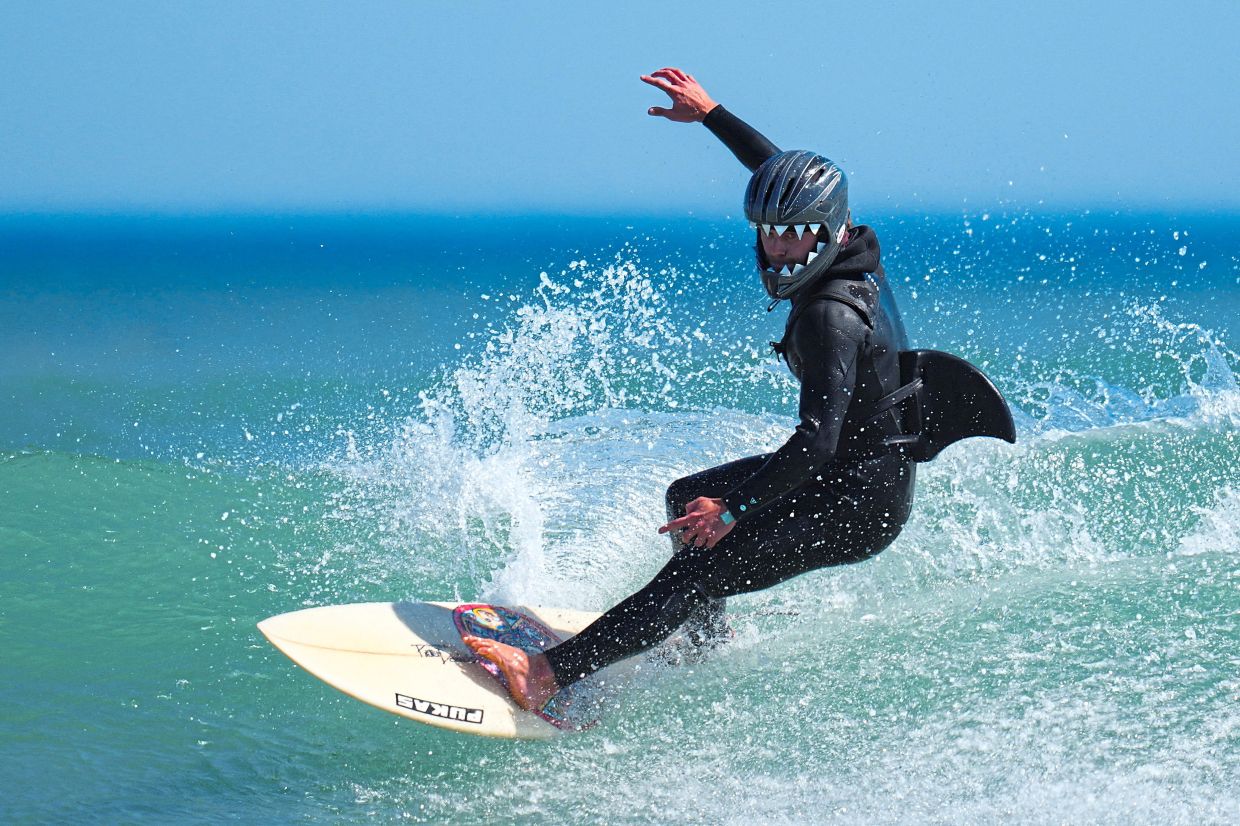 2. A surfer taking part in the Kommetjie festival’s fancy dress surf competition, a unique community event celebrating the festive atmosphere of Kommetjie, a seaside village on the west coast of the Cape Peninsula, Cape Town, South Africa. — Reuters