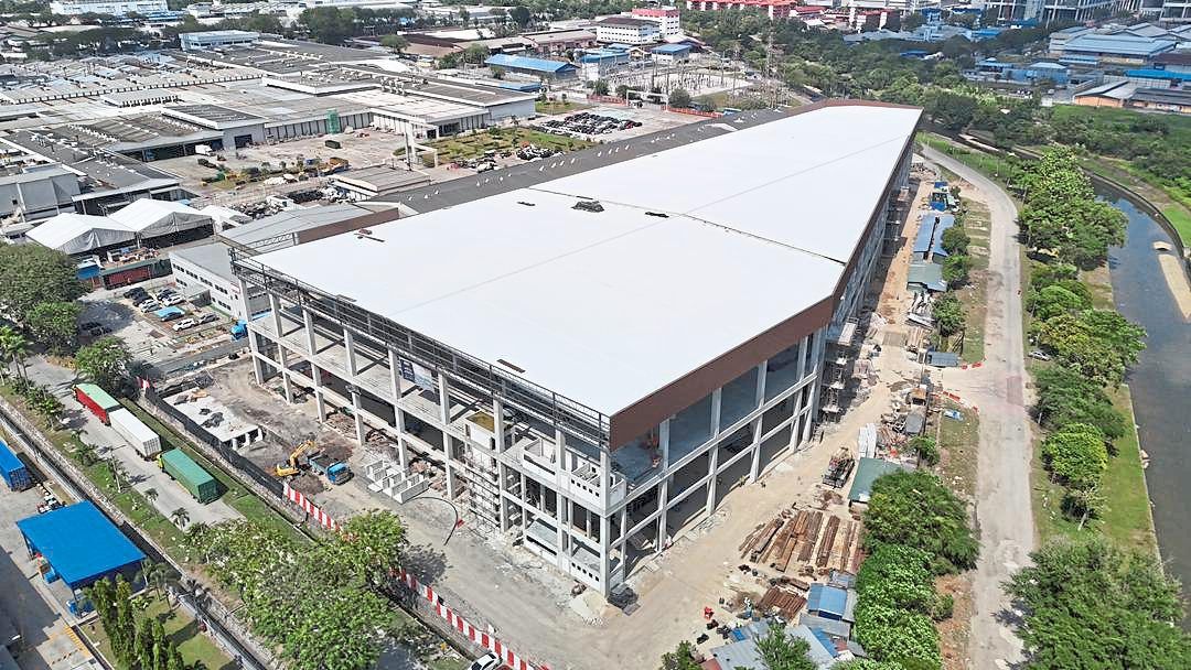 Construction progress of the warehouse facility as of November, displaying significant structural completion and ongoing works around the loading and logistics areas.