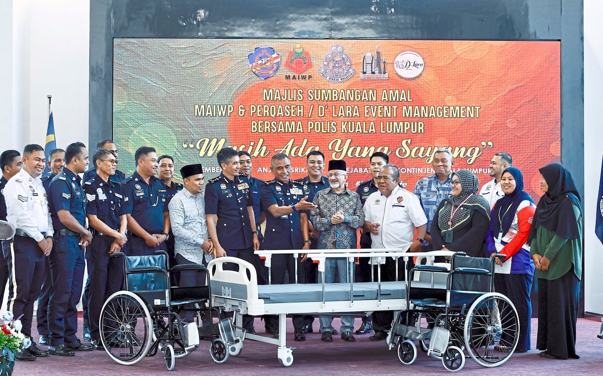 A time to give: Comm Fadil sharing a light moment with recipients of the ‘Masih Ada Yang Sayang’ donation programme at the police headquarters in Kuala Lumpur. — FAIHAN GHANI/The Star