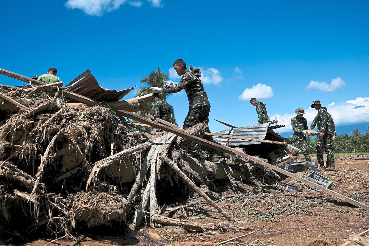 Soldiers walking among rubble during a rescue operation in Palembayan, West Sumatra province. — AFP/Reuters