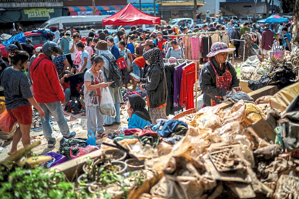 People shopping for flood-damaged products following deadly flooding in Hat Yai district, Songkhla province. — AFP/Reuters