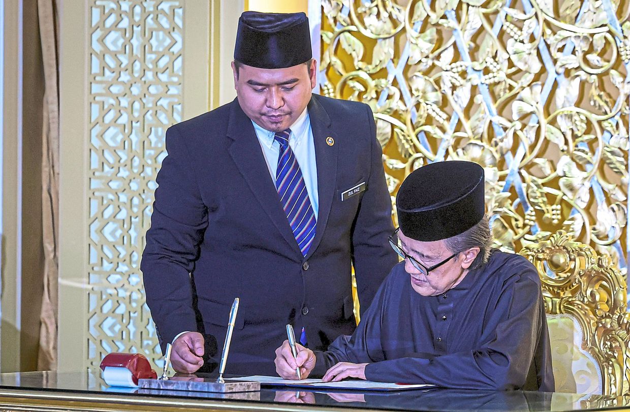 Masidi signing his oath of office.— Bernama