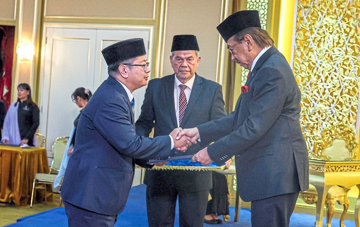 Musa (right) presenting the oath of office to Ewon at Istana Seri Kinabalu. — Bernama