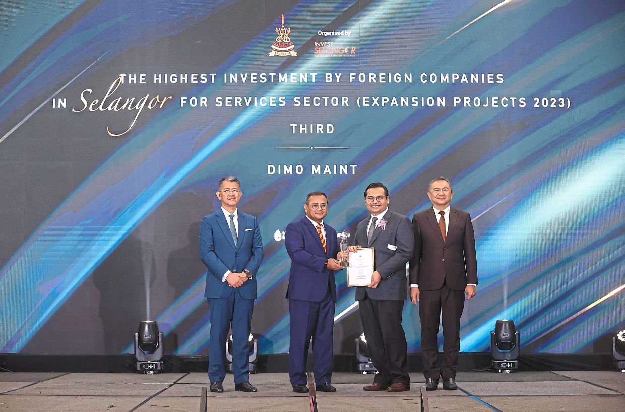 Amirudin (second left) presenting the award to Muhammad Faris (second right) witnessed by Ng (right) and Hasan Azhari (left) during the Selangor Investors Appreciation Awards 2023 - 2024 at the Setia City Convention Centre in Setia Alam, Selangor.—MUHAMAD SHAHRIL ROSLI/The Star