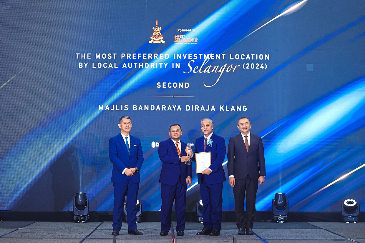 Amirudin (second left) presenting the award to Abd Hamid (second right) witnessed by Ng (right) and Hasan Azhari (left) during the Selangor Investors Appreciation Awards 2023 - 2024 at the Setia City Convention Centre in Setia Alam, Selangor.