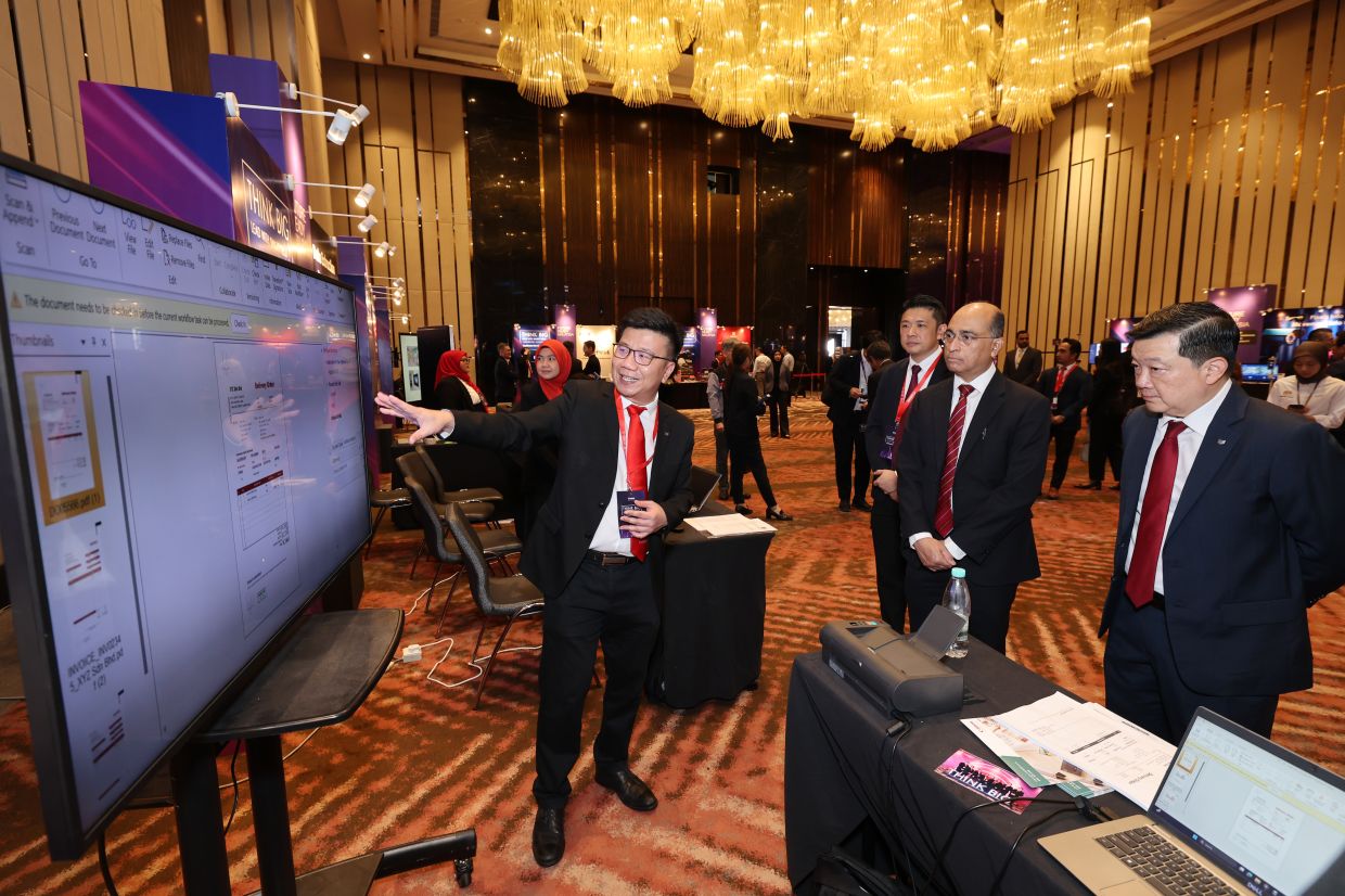 A Canon representative briefing MyDIGITAL chief executive officer Adrian Marcellus on Canon business solutions that support Malaysia’s digital ambitions and help businesses accelerate digitalisation.