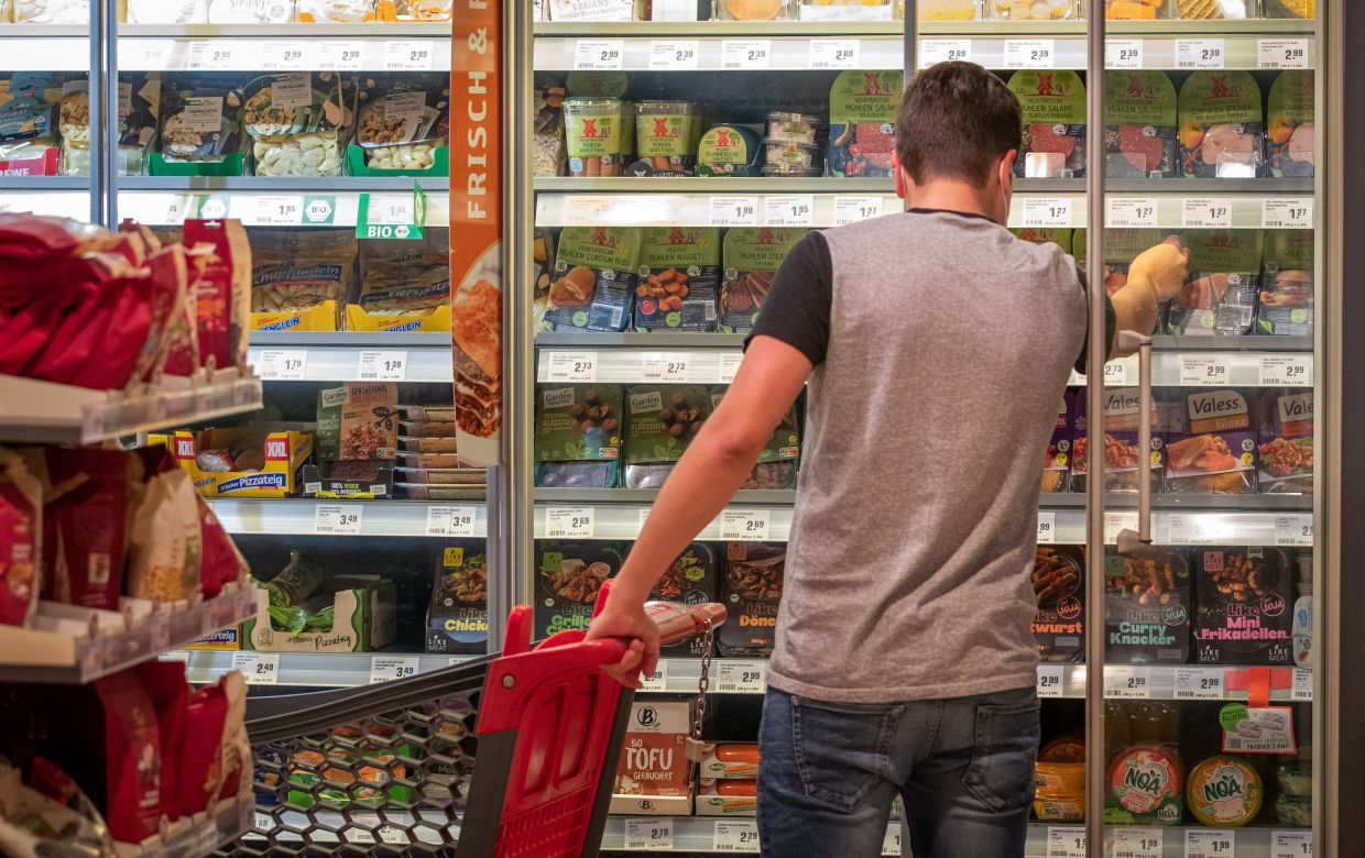 Products for vegetarians and vegans are displayed on a refrigerated shelf of a food retailer. Photo: Friso Gentsch/dpa