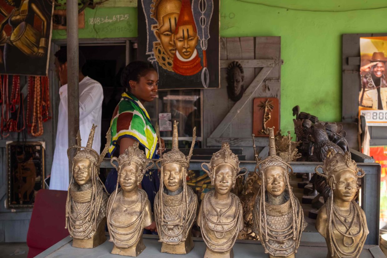 A tourist looks at bronze art pieces on display for sale in a shop on Igun Street. — Photo: TOYIN ADEDOKUN / AFP