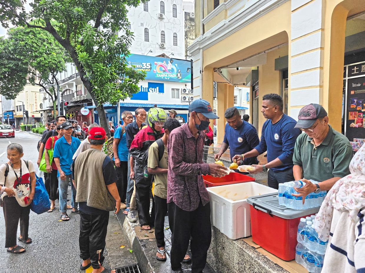Volunteers serving packed meals to the needy near Central Market in Kuala Lumpur. 