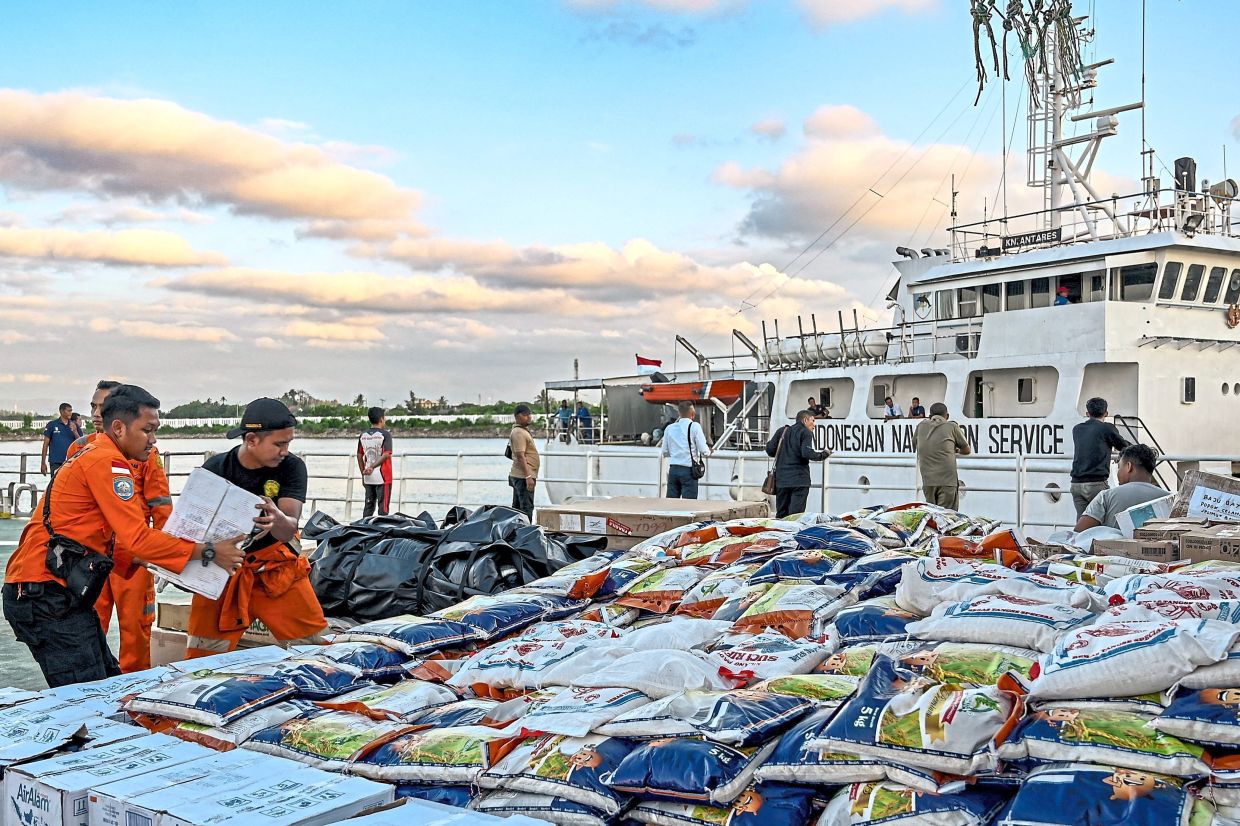 Precious cargo: Members of the National Search and Rescue Agency loading supplies for flood victims in Aceh province. — AFP