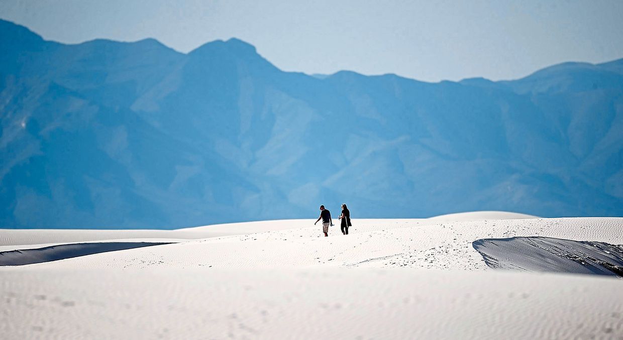 Hikers head across a dune in White Sands National Park at Holloman Air Force Base, New Mexico.