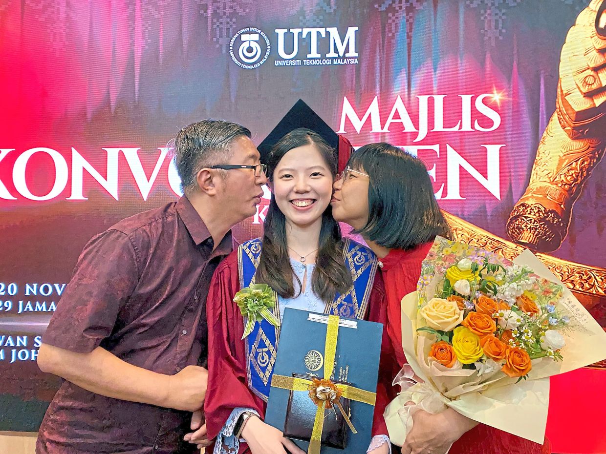 Royal grant recipient Che’er (centre) with her parents after receiving her scroll. — Photos: MYSARA FAUZI