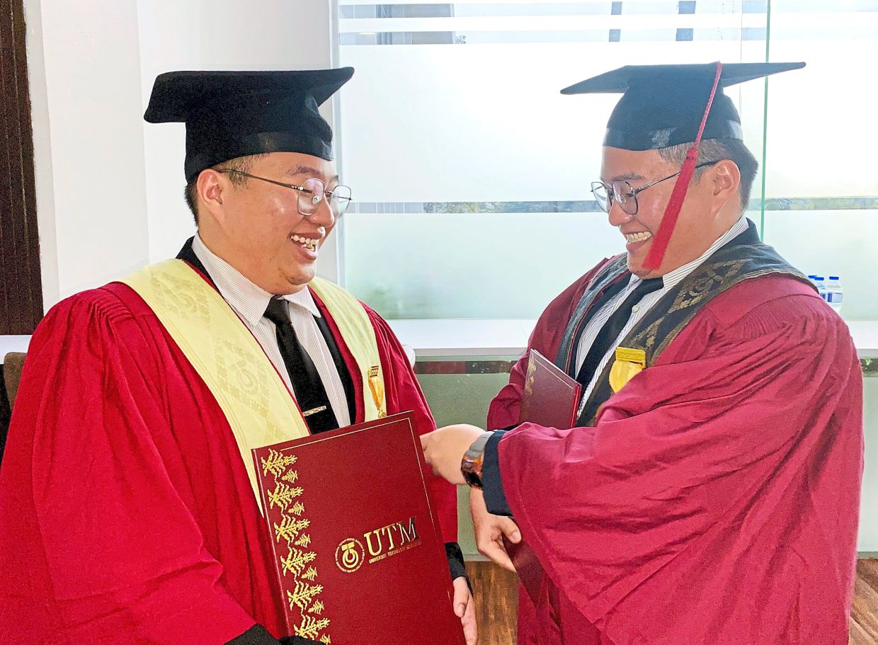 Jack (right) adjusting his twin brother Alan’s graduation robe.