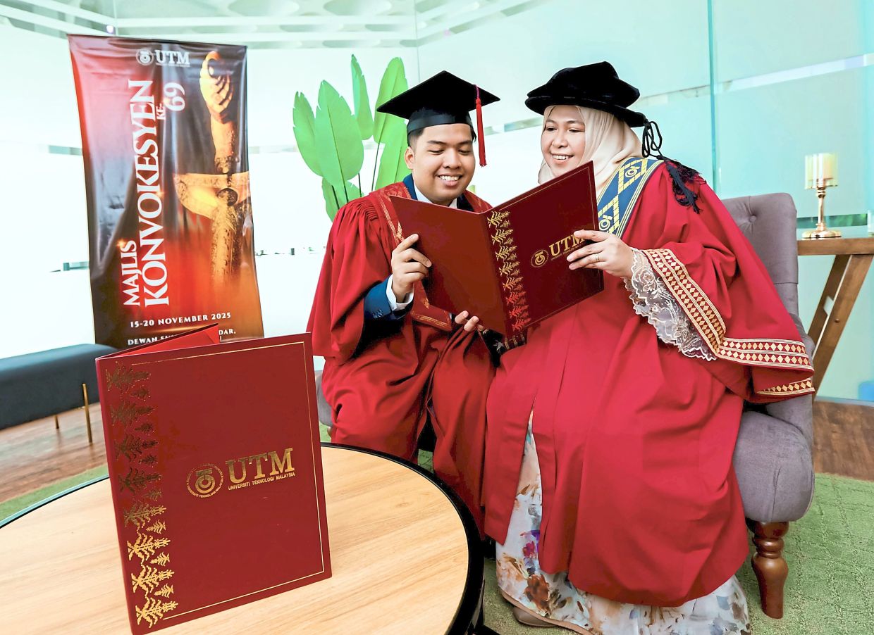 Azura (right) and her son Afif Izhar looking at their well-deserved scrolls.