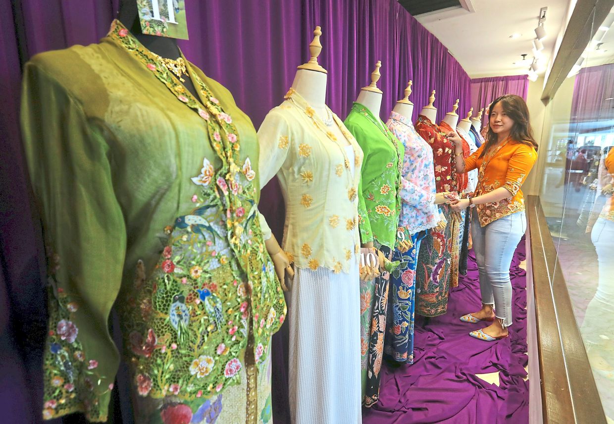 Persatuan Peranakan Baba Nyonya Kuala Lumpur & Selangor secretary Madeleine Teh admiring the kebaya showcased at the event.