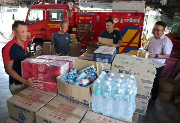 (From right) Air Itam assemblyman Joseph Ng, Bukit Bendera Volunteer Fire Brigade operations chief Teoh Chuang Piau and two other members checking the food items to be brought to flood victims in Hat Yai, Thailand. — ZHAFARAN NASIB/The Star