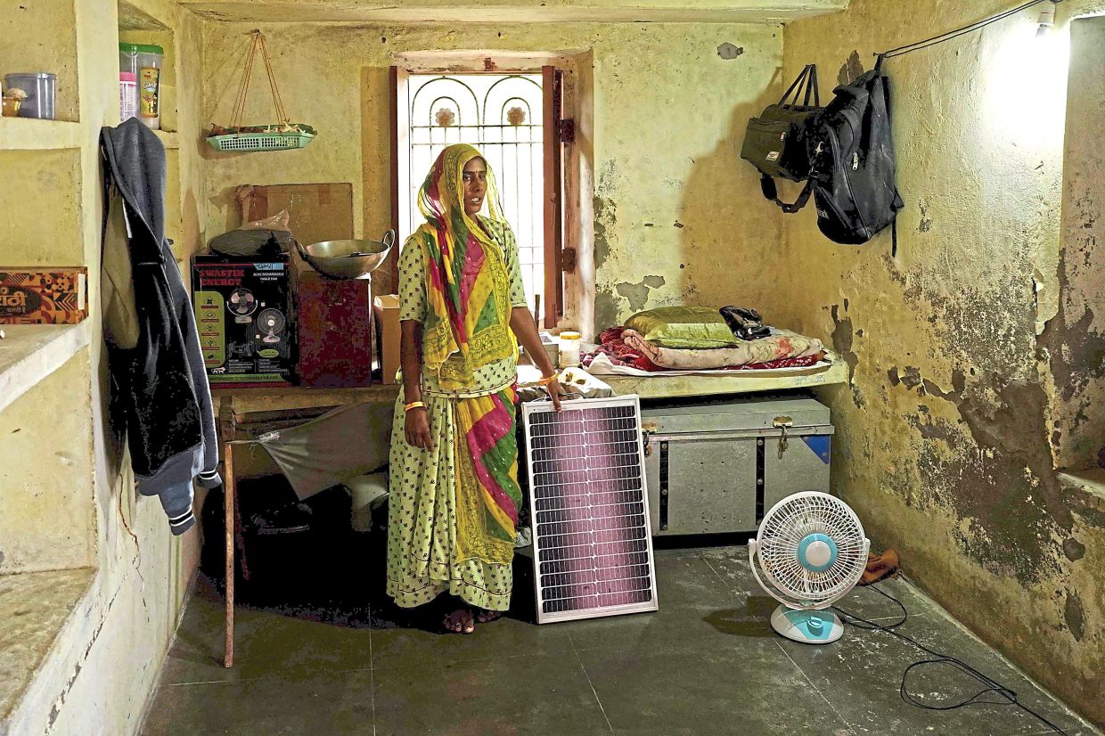 Like the one she is holding, for a few villagers but has yet to be paid. — AFP