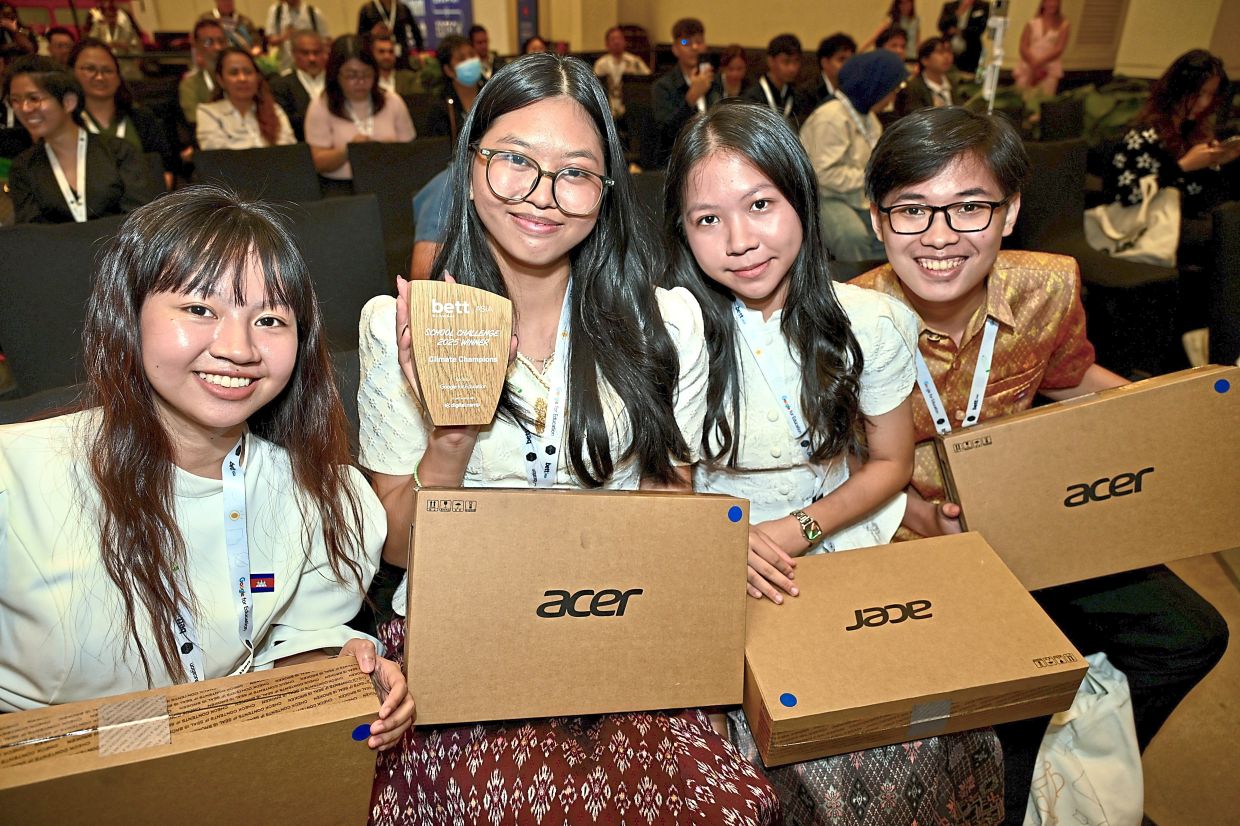 Conquering with confidence: (From second left) Reaksmeyniza, Meiling and Haysin sharing a proud moment with their adviser, Sereysure Sun (far left), after their win.