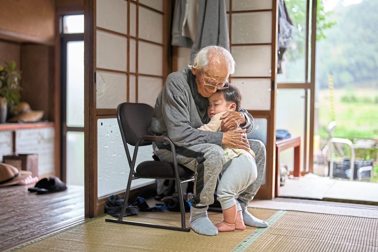 Farmer Matsuo, 101, plays with his one-year-old great-grandson Toki every weekend. — CHANG W LEE/The New York Times