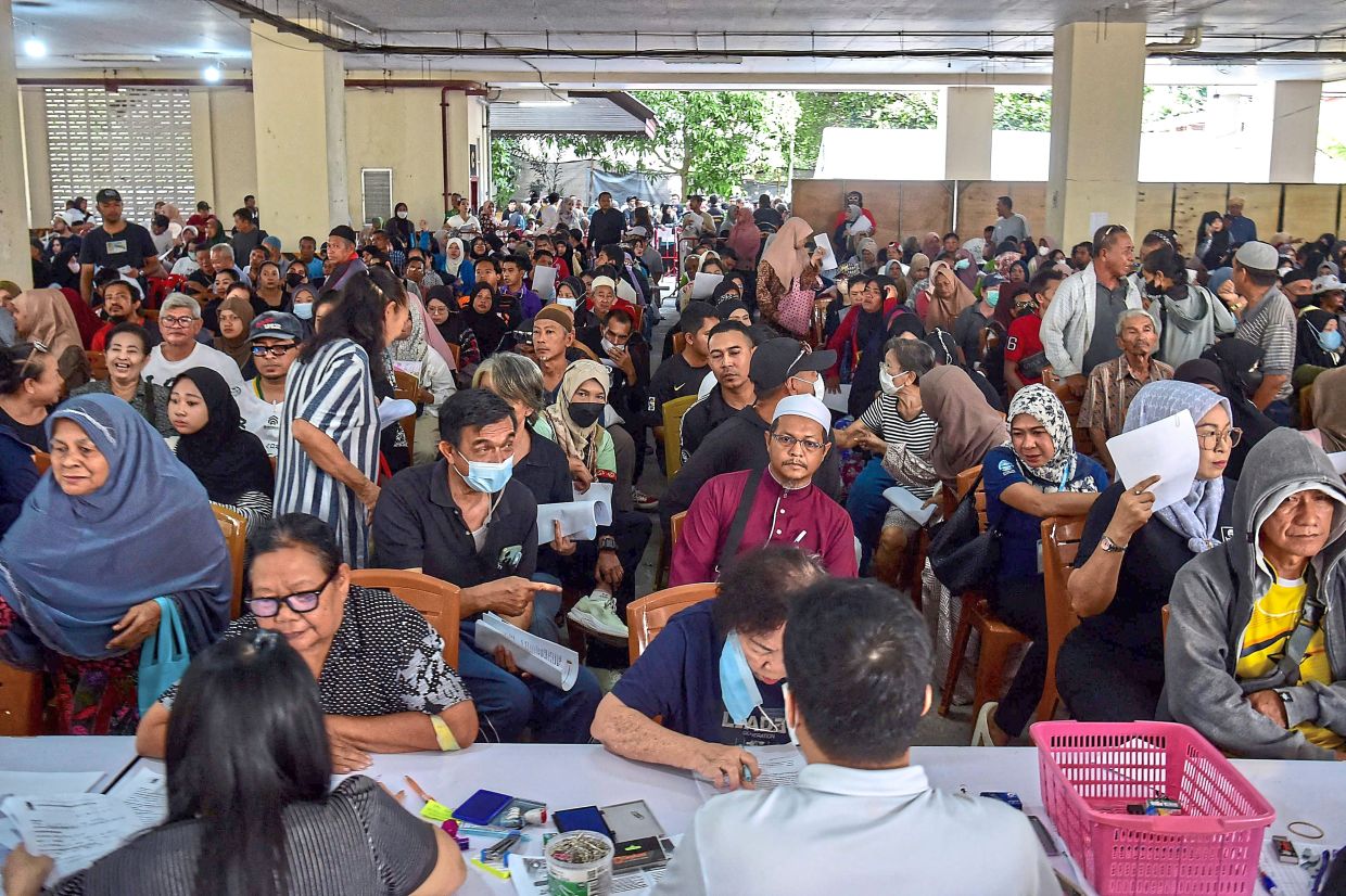 Much-needed aid: Flood victims registering to receive disaster relief funds at the Narathiwat municipality building after severe flooding affected thousands of people in the region. — AFP